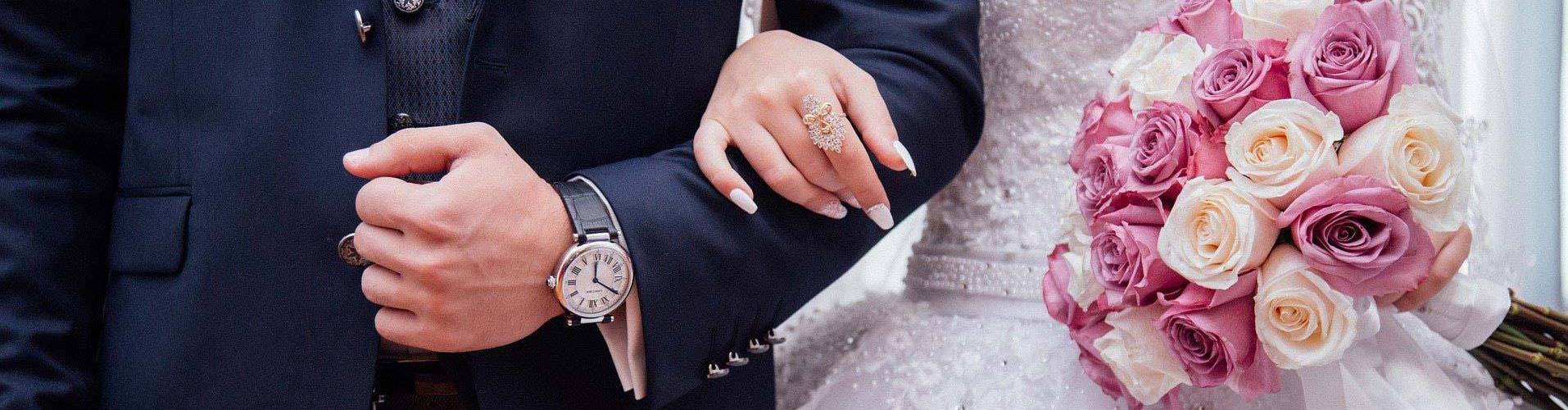 Quelle: pixabay.de / StockSnap Hochzeitspaar hält sich am Arm mit Blumen